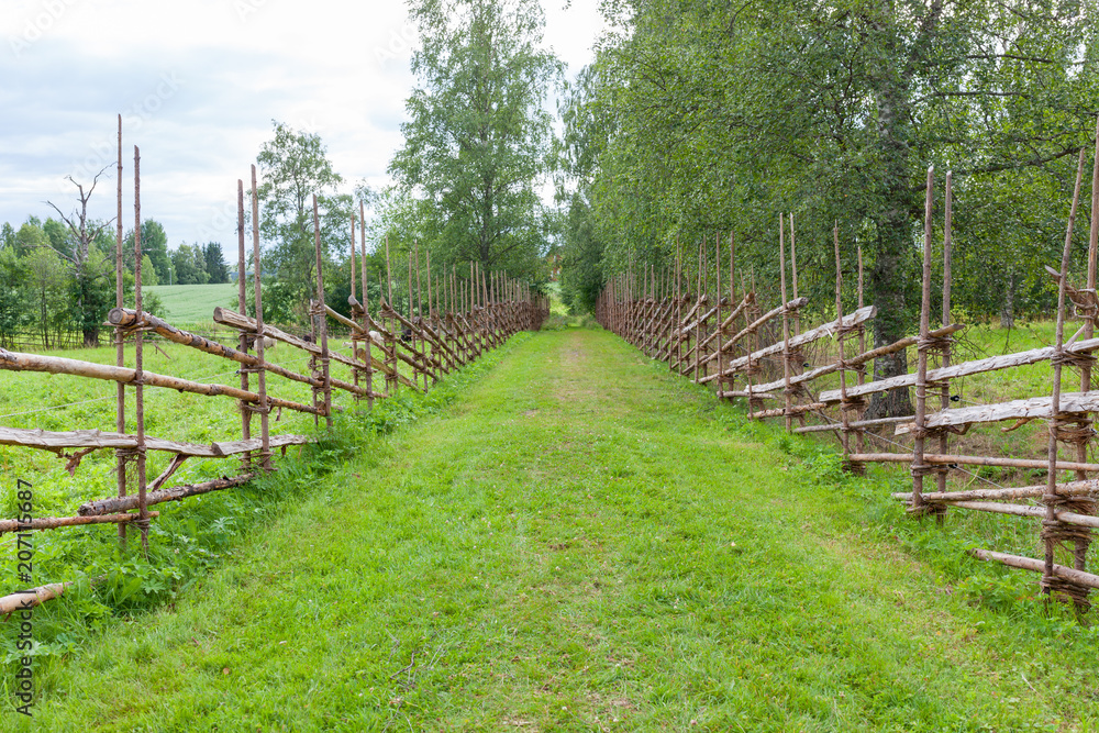 Old traditional wooden fence and road in finland
