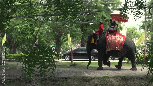  Phra Nakhon Si Ayutthaya Province / Thailand - May 28 2018 : tourist on elephant ride at Ayutthaya Historical Park slow motion shot