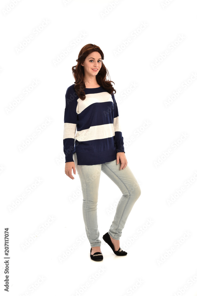 full length portrait of girl wearing striped blue and white jumper and jeans. standing pose on white studio background full length portrait of girl wearing striped blue and white jumper and jeans. standing pose on white studio background