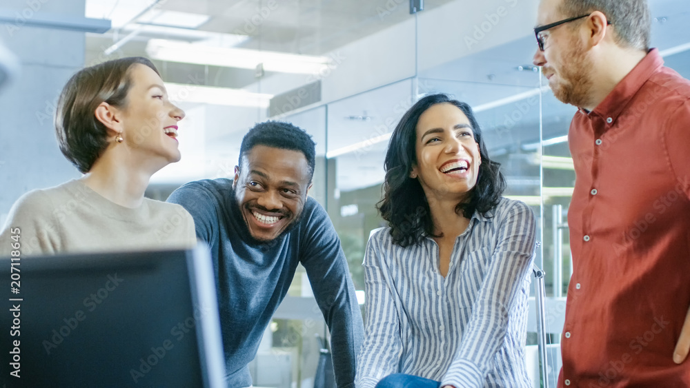 Fototapeta premium Diverse Group of Four Talented Young Professionals Having Team Building Conversation, Joking and Having Fun. Talented Young People in Modern Office.
