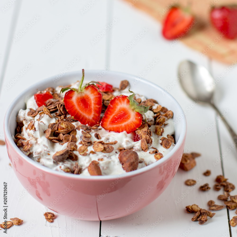 Granola with yogurt, strawberry in a pink bowl, healthy breakfast Granola with yogurt, strawberry in a pink bowl, healthy breakfast