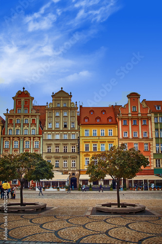 Wroclaw Market Square with old colorful houses against bright blue sky. Mid day sunlight in historical capital of Silesia Poland  Europe. Travel vacation concept