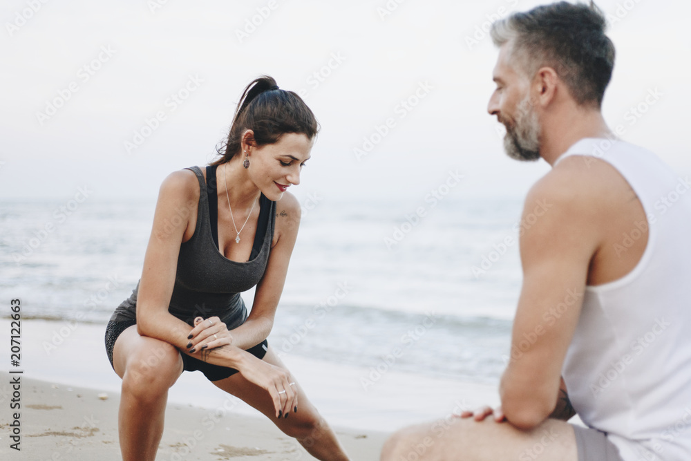 Couple stretching at the beach Couple stretching at the beach