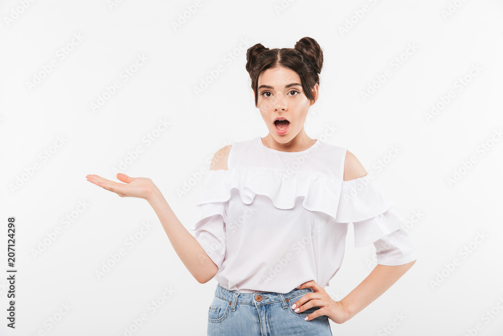 Photo closeup of advertising teenage woman with double buns hairstyle and dental braces expressing surprise and holding copyspace at her palm, isolated over white background Photo closeup of advertising teenage woman with double buns hairstyle and dental braces expressing surprise and holding copyspace at her palm, isolated over white background