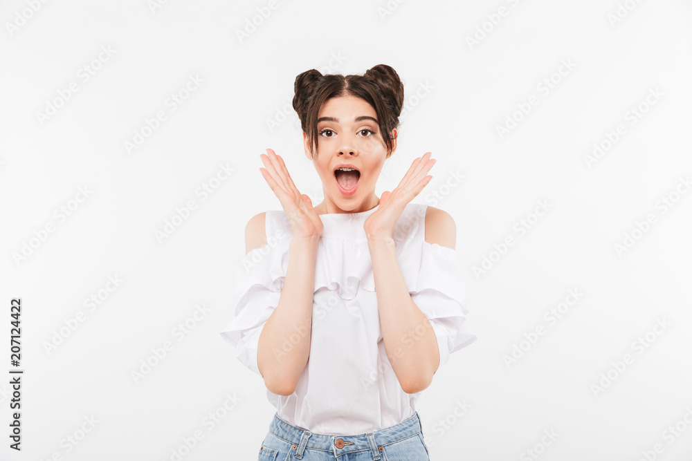 Photo closeup of excited teenage woman with double buns hairstyle and dental braces shouting in surprise or delight raising hands at face, isolated over white wall Photo closeup of excited teenage woman with double buns hairstyle and dental braces shouting in surprise or delight raising hands at face, isolated over white wall