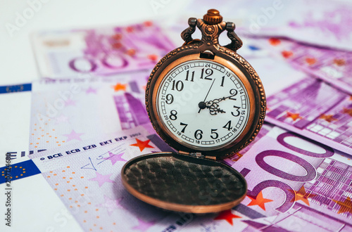 Old pocket watch with euro banknotes money, macro view. Time and business concept. © Alice Fox