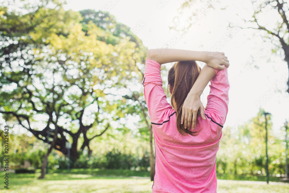 Asian young woman warm up the body stretching before morning exercise and yoga in the park under warm light morning. Healthy young asian woman exercising at park. Woman exercise outdoor concept. Asian young woman warm up the body stretching before morning exercise and yoga in the park under warm light morning. Healthy young asian woman exercising at park. Woman exercise outdoor concept.