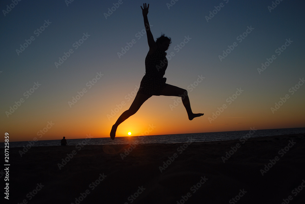CHICA SALTANDO EN LA PLAYA AL ATARDECER CHICA SALTANDO EN LA PLAYA AL ATARDECER