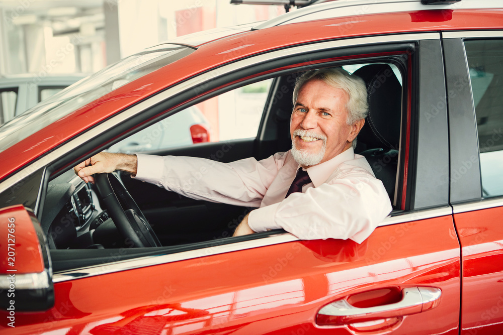 Adult man buy car and holding a key of his new car, looking at camera and smiling.