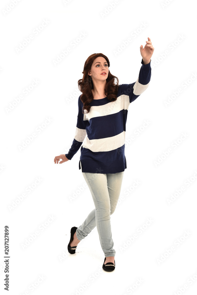 full length portrait of girl wearing striped blue and white jumper and jeans. standing pose on white studio background full length portrait of girl wearing striped blue and white jumper and jeans. standing pose on white studio background