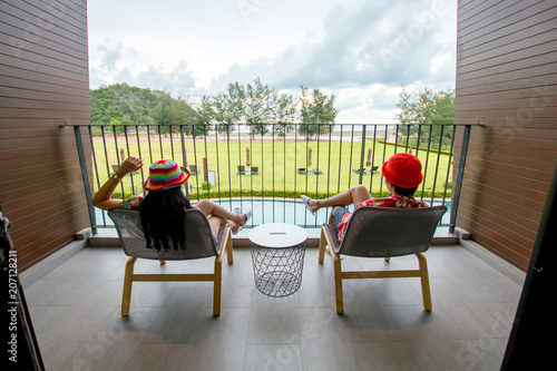 beautiful view looking from bedroom of resort and couple asian people sitting at chair, relaxation in vacation concept © karimpard