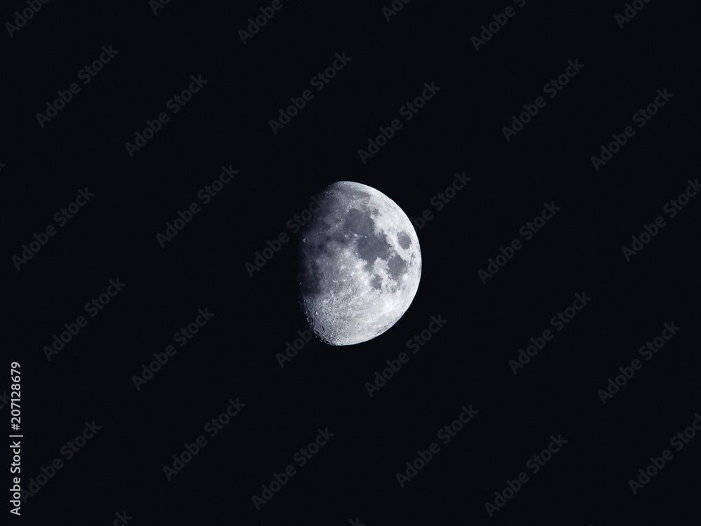 Natural night background with dark sky and half Moon, Earth satellite. Waxing gibbous phase.