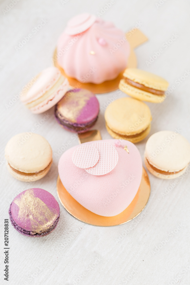 Fototapeta premium Pink mousse-cake. French macaroon dessert and flowers eucalyptus on a white background. pastel colors