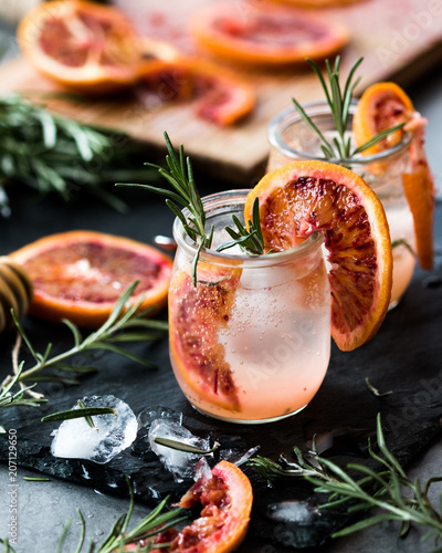 rosemary and bloody oranges water in a transparent glass with ice