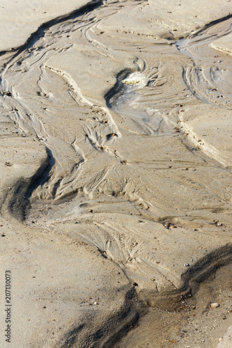 View on beautiful sandy structures and lines caused by waves on the beach