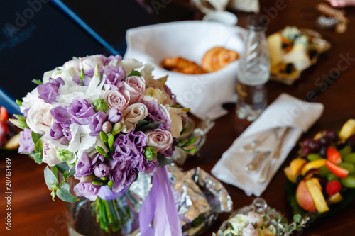 Bouquet of flowers in vase on the background of snacks on the table. Beautiful fresh flowers on the wedding table