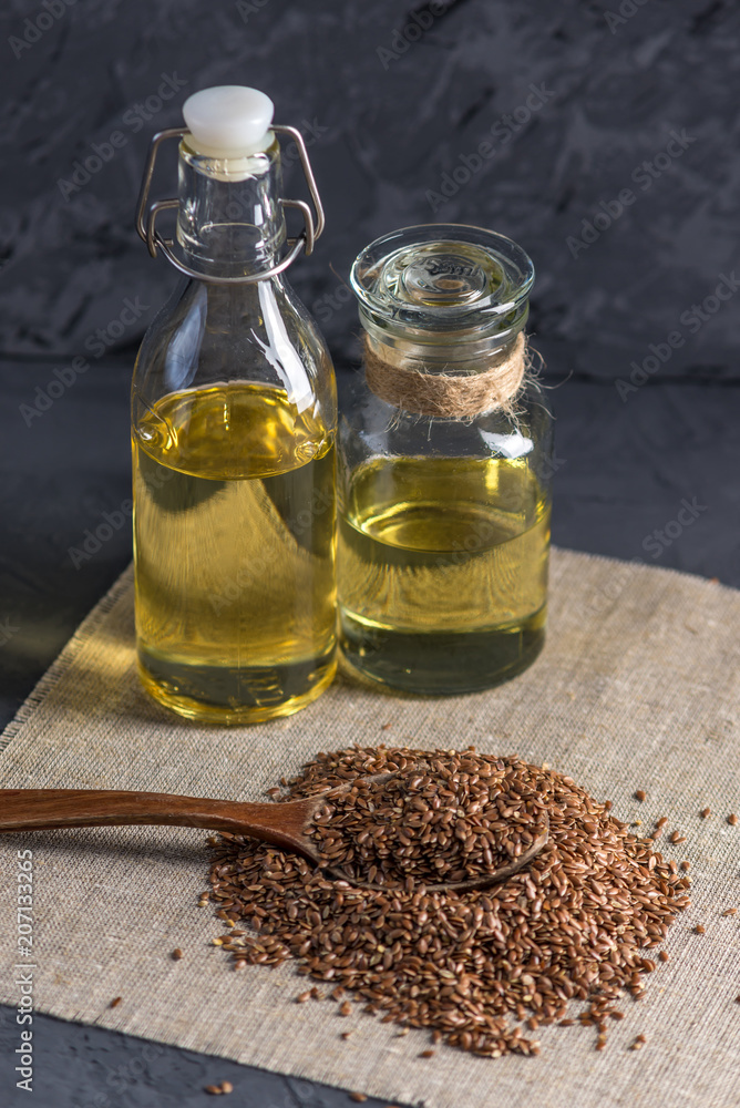 Flax seeds with spoon and linseed golden oil in a glass bottle on the table. Healthy diet with omega 3 fatty acids. Flax seeds with spoon and linseed golden oil in a glass bottle on the table. Healthy diet with omega 3 fatty acids.