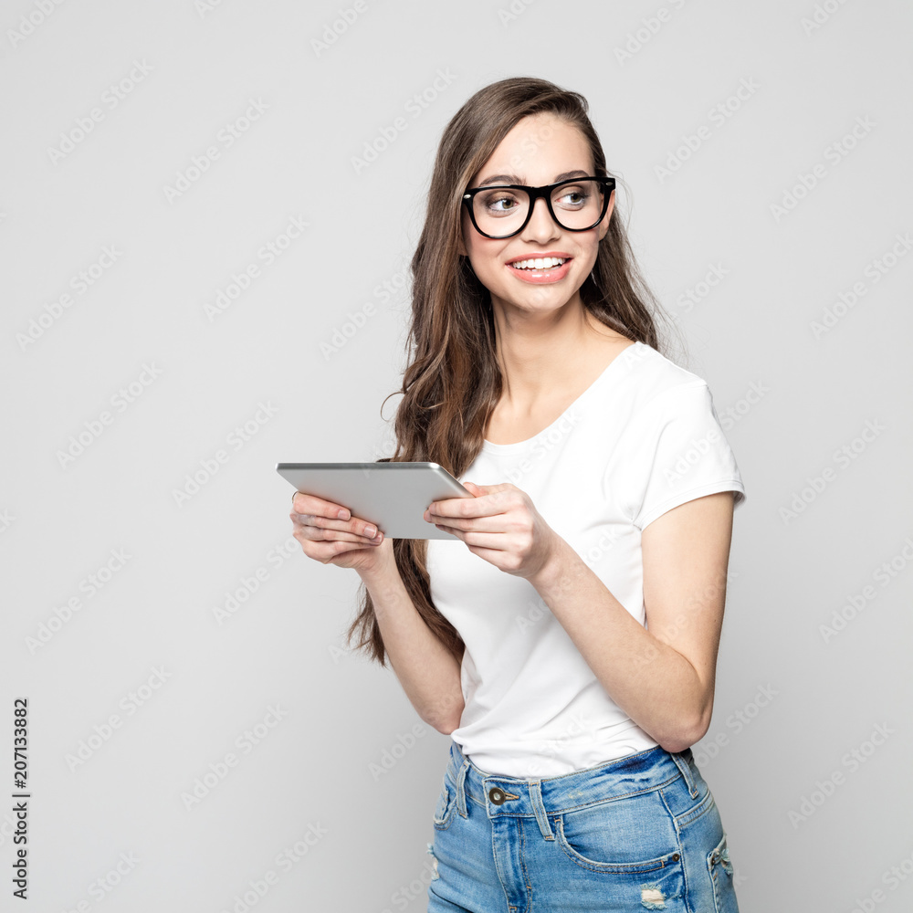 Portrait of beautiful female student wearing nerd glasses, holding digital tablet Portrait of beautiful female student wearing nerd glasses, holding digital tablet
