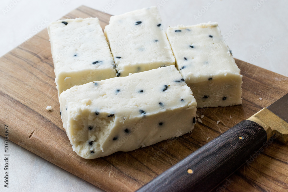 Turkish Feta Cheese with Black Cumin (Sesame) Seeds on Wooden Surface with Knife. Turkish Feta Cheese with Black Cumin (Sesame) Seeds on Wooden Surface with Knife.