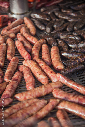 Different kinds of fresh spanish sausages hanging in bunches on the marketplace. Soft focus.7