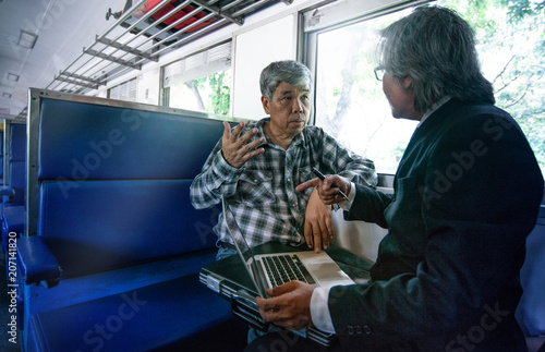 Asian business man and project manager confident in the project agreed, in train near window,.