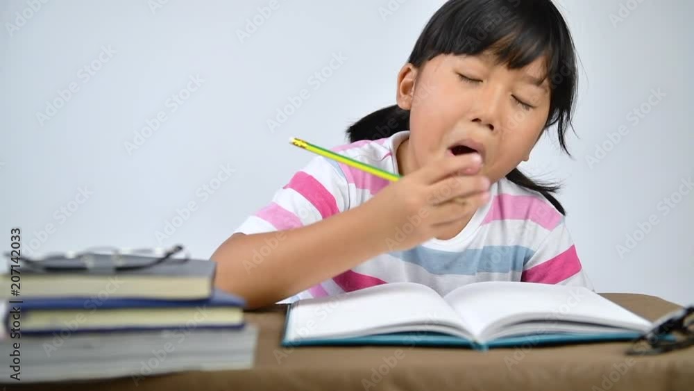 Asian girl student yawn and sleep while doing homework. education concept Asian girl student yawn and sleep while doing homework. education concept