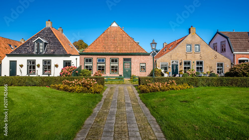 Old and gorgeous houses are scattered along the main street of the village of Schiermonnikoog on the Dutch Wadden Isle of the same name. Photo is shot in September. photo
