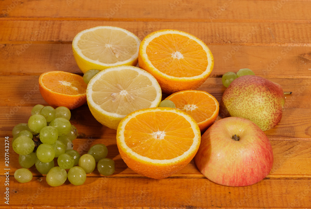 Grapes, lemon, orange,Apple, pear cut into slices on a wooden background. Grapes, lemon, orange,Apple, pear cut into slices on a wooden background.