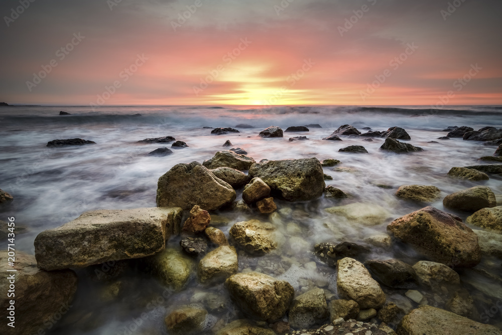 Seascape at sunrise with rocks and waves against a vibrant sky.Saint constantine and Elena beach. Seascape at sunrise with rocks and waves against a vibrant sky.Saint constantine and Elena beach.