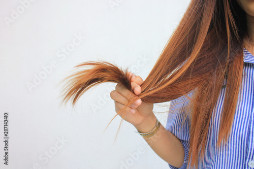 Woman holding at damaged splitting ends of hair, Haircare concept