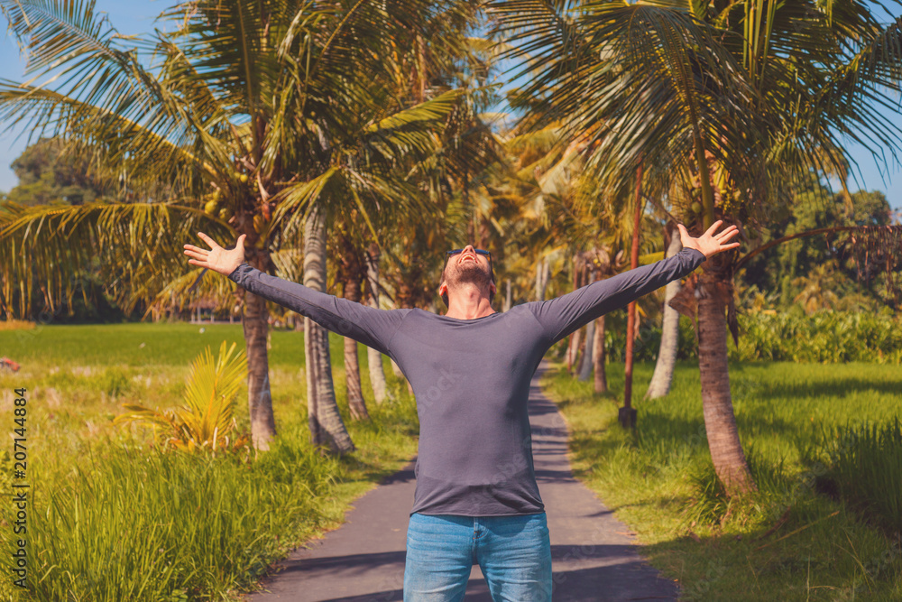 Man enjoying tropical climate with arms wide open.