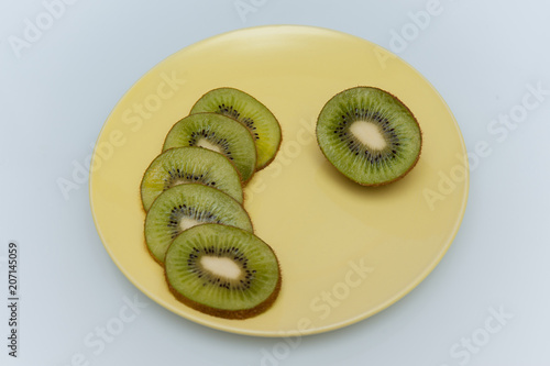 sweet ripe kiwi fruits on white, Kiwi cut into slices lay on a yellow plate, serving fruit