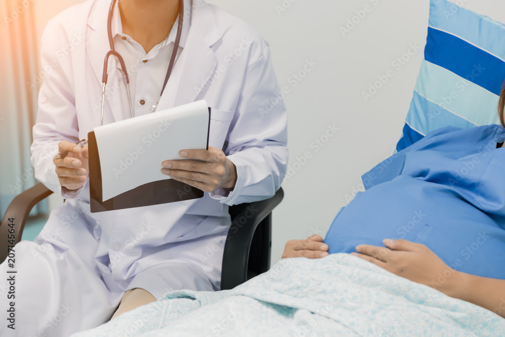 Pregnant young woman visiting doctor.Consultation of pregnant young woman with doctor in hospital. Pregnant young woman visiting doctor.Consultation of pregnant young woman with doctor in hospital.