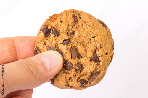 Hand h  lt leckeren Schokoladen Cookie in der Hand vor wei  em Hintergrund freigestellt in Nahaufnahme