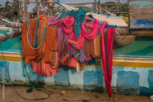 Bunte Fischernetze liegen gestapelt auf einem Boote am Strand von Sri Lanka