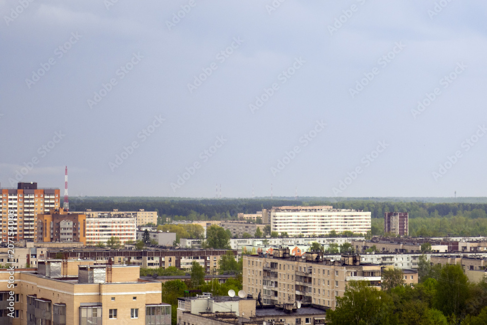 A small city, buildings, trees and sky, cloudy weather