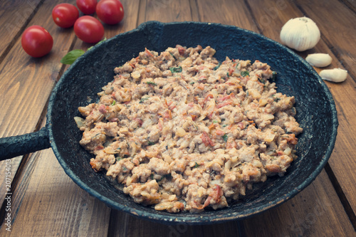 Bilde på lerret Appetizing fried minced meat with vegetables and greens in rustic old frying pan