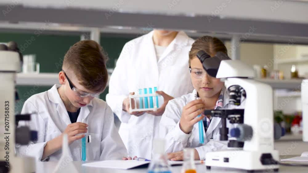 education, science and children concept - teacher and students with test tubes studying chemistry at school laboratory education, science and children concept - teacher and students with test tubes studying chemistry at school laboratory