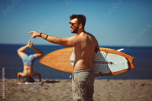 Young man with a surf board on the beach