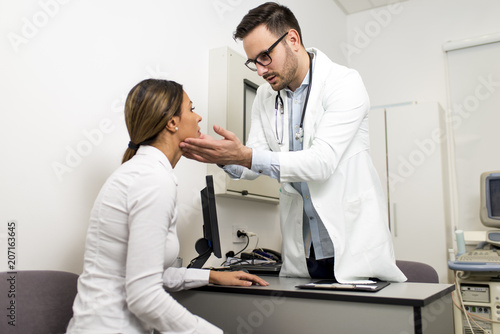 Male doctor examines a fema...