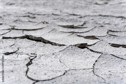 background - cracked dry sun-dried clay crust in a waterless desert