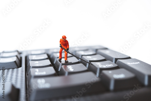 Miniature people, engineer standing on computer keyboard using as technology and business concept