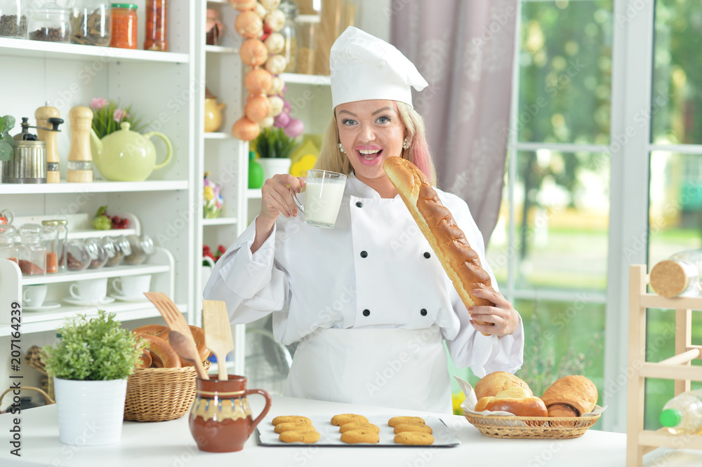 Beautiful young woman in chefs hat preparing delicious cookies Beautiful young woman in chefs hat preparing delicious cookies
