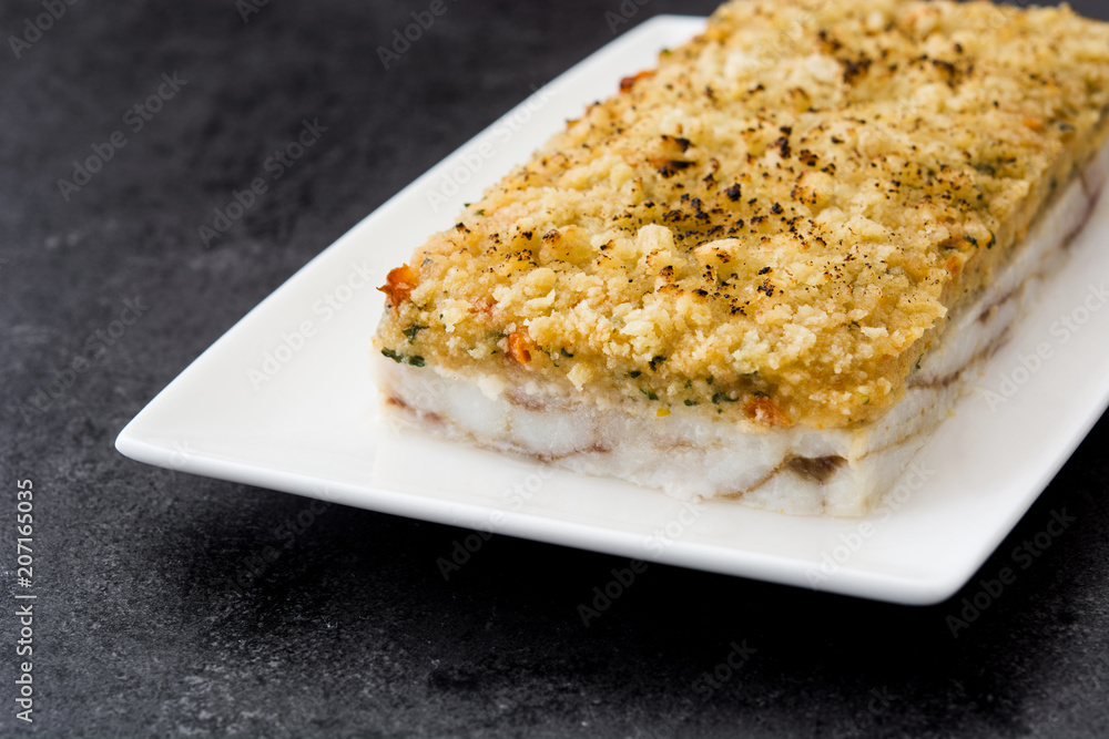 White fish casserole with cheese on black stone