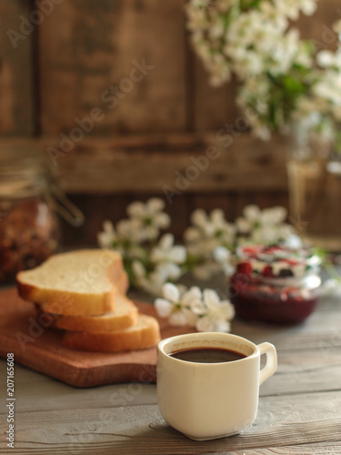 black coffee in a white cup and flowers (portion of hot coffee)