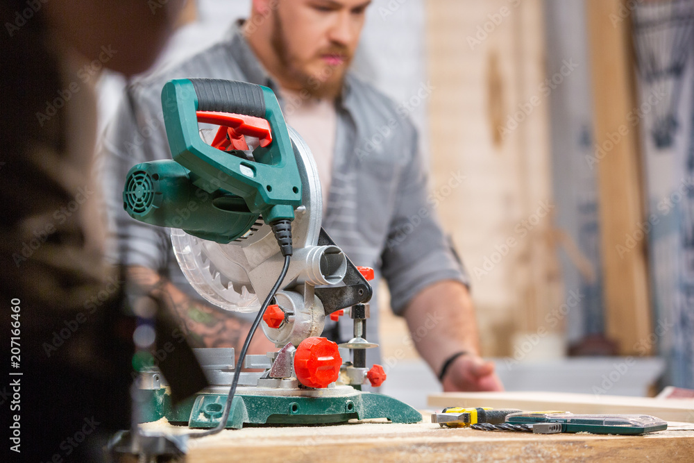 Man sawing wood with a circular saw on a workbench