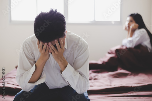 Handsome man get disappointed that his wife tell him for divorce because she get new boyfriend. Guy get shocked, sadness and unhappy. He use his hands to close his face with girlfriend background