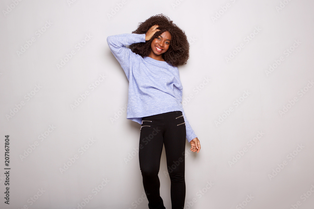 stylish young african woman standing with hand in hair on white background stylish young african woman standing with hand in hair on white background