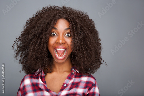 Close up excited young woman laughing with open mouth on gray background photo