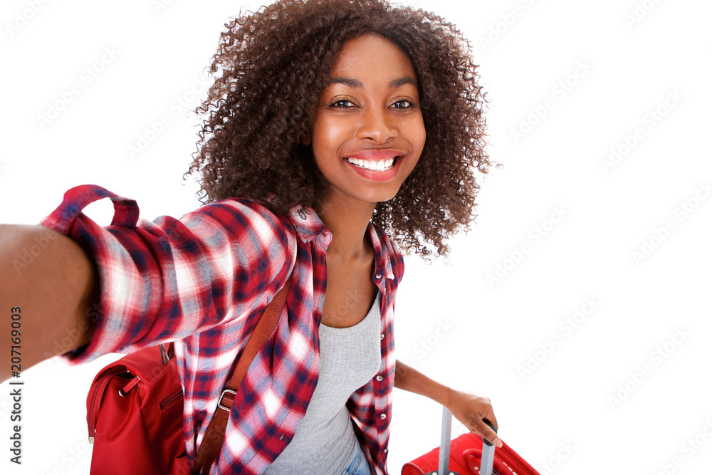 © mimagephotos - attractive young female traveler taking selfie on white background